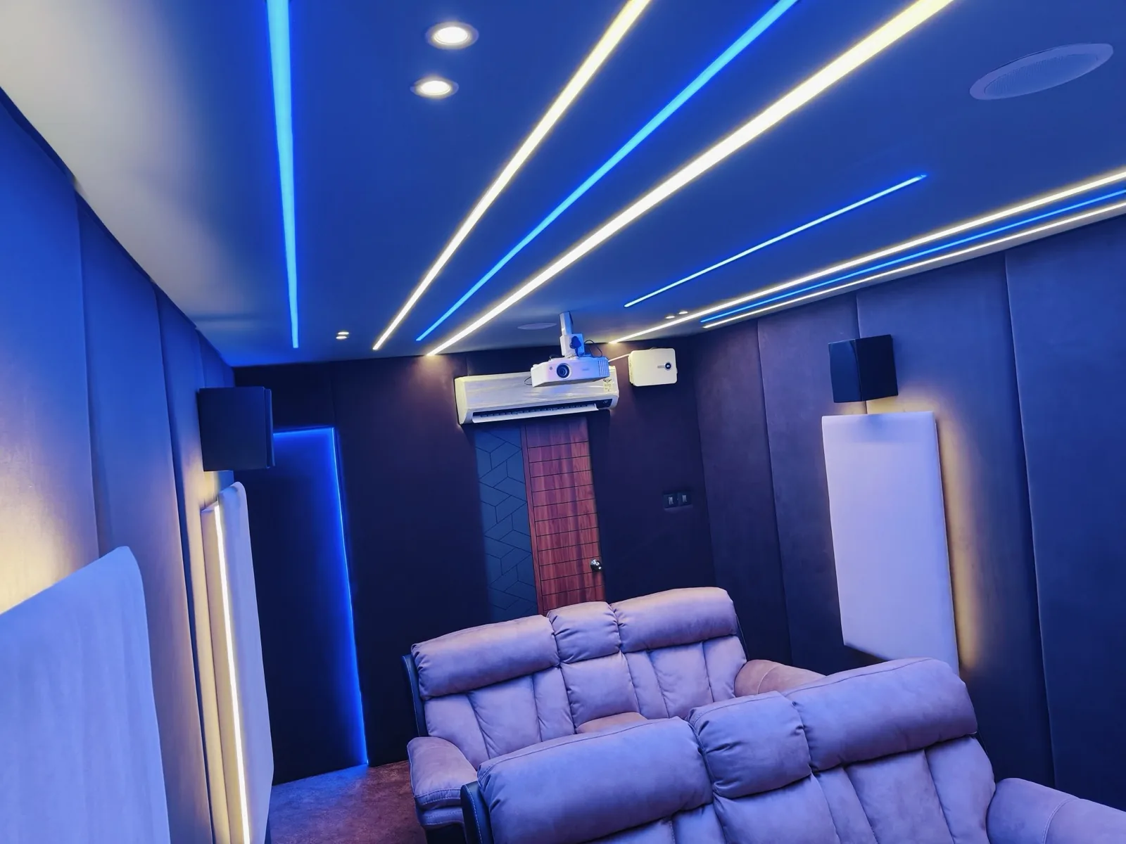 Home theatre room with recliners and blue LED cove lighting
