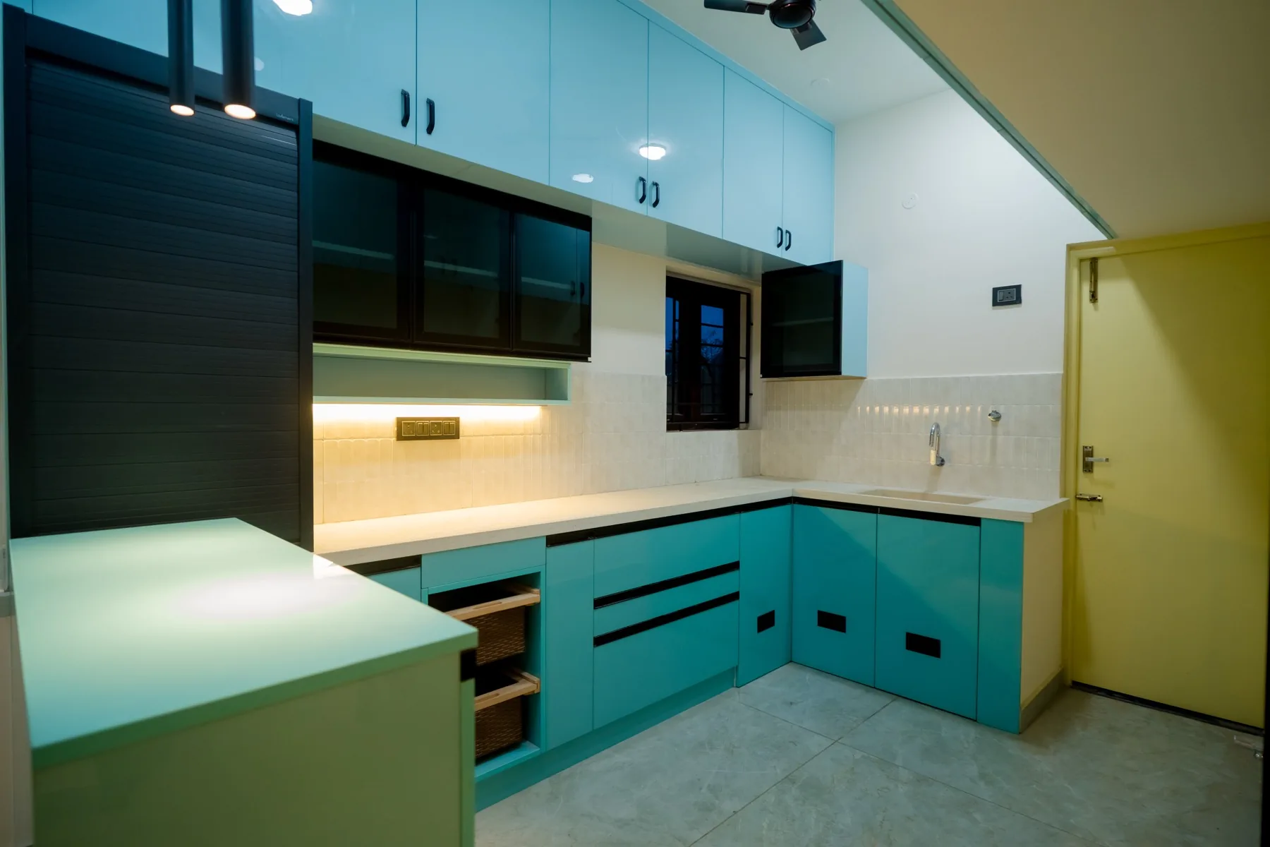 Modular kitchen with teal cabinetry and stone counters